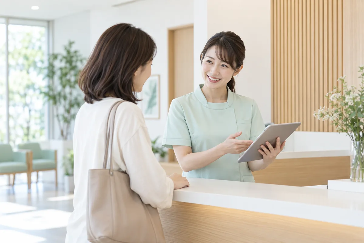 タブレットで来院者を案内する受付スタッフのイメージ